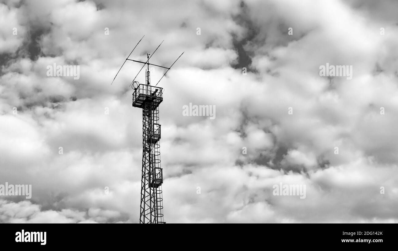 Antenne für Kommunikation und Fernsehen und Radio mit bewölktem Himmel im Hintergrund, schwarz-weiß-Bilder Stockfoto