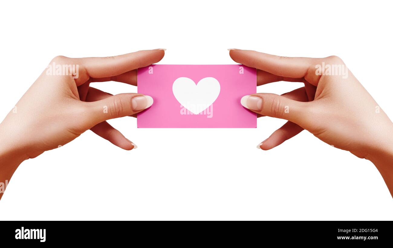 Valentinskarte mit Herz in weiblicher Hand auf weißem Hintergrund. Zartrosa Geschenkkarte. Liebe und Glück Symbol. Stockfoto