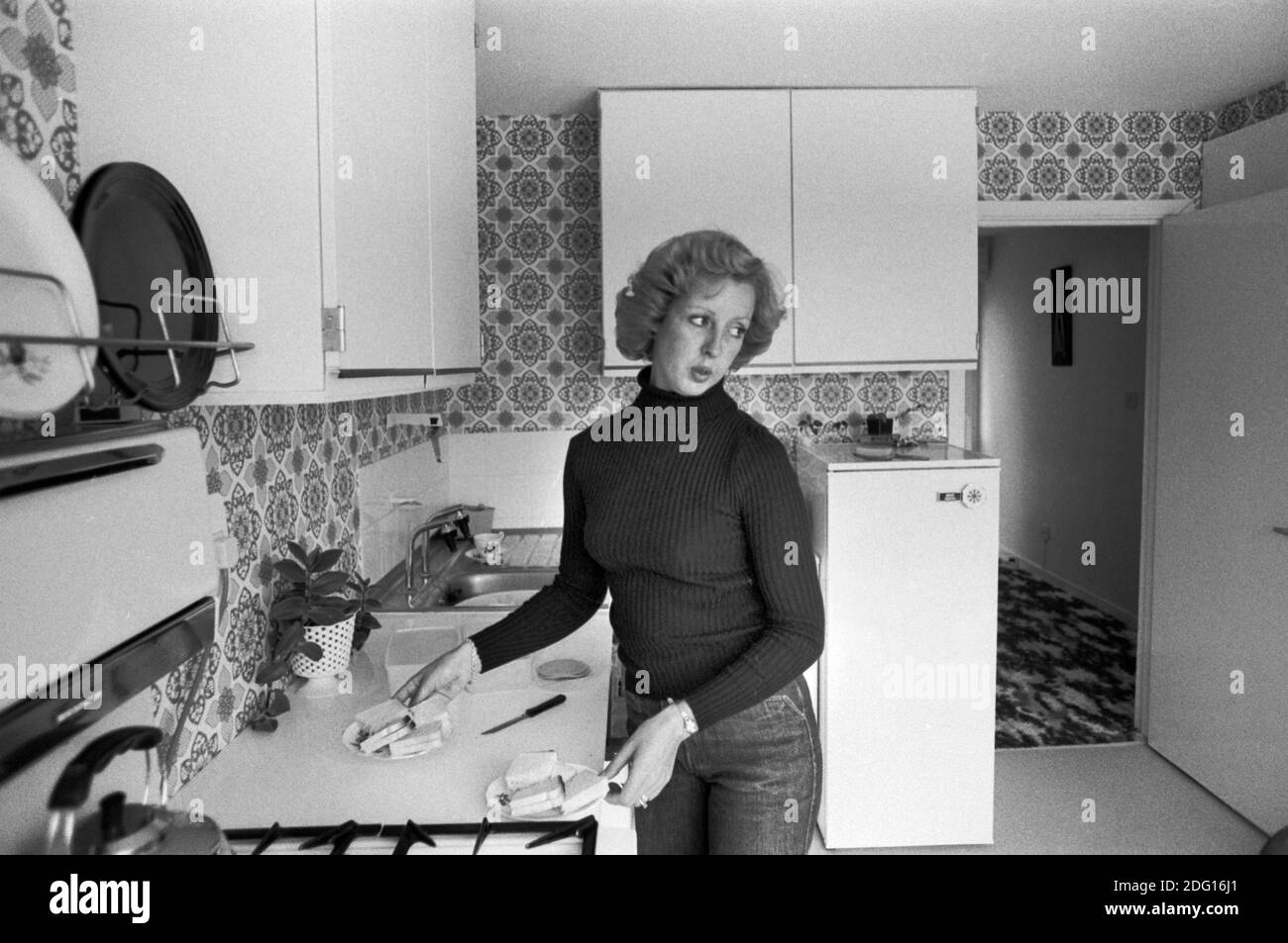 1970s England, eine professionelle Mutter mit mittlerem Einkommen zu Hause in der Küche, die Nachmittagstee zubereitet, Sandwiches für die zwei Jungen 1977 New town Modern Housing Development UK HOMER SYKES Stockfoto