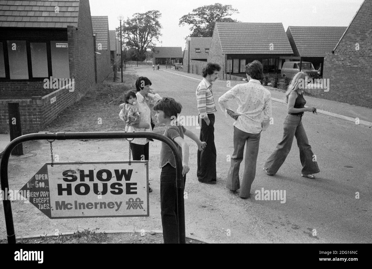 Milton Keynes New Town Buckinghamshire 1970s UK. Neue moderne Wohnsiedlung. Entwicklungszeichen für „Show Home“. Leute auf der Straße, die sich mit dem Schild zum Show House vertraut machen. 1977 England HOMER SYKES Stockfoto