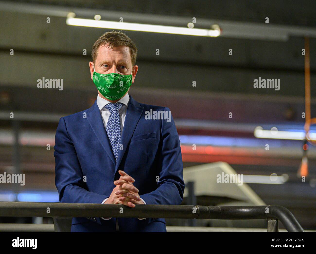 Ottendorf Okrilla, Deutschland. Dezember 2020. Michael Kretschmer (CDU, rechts), Ministerpräsident von Sachsen, steht bei seinem Besuch im DHL-Paketzentrum an einem Transportband für Pakete und trägt einen Mund- und Nasenschutz. Quelle: Robert Michael/dpa-Zentralbild/dpa/Alamy Live News Stockfoto
