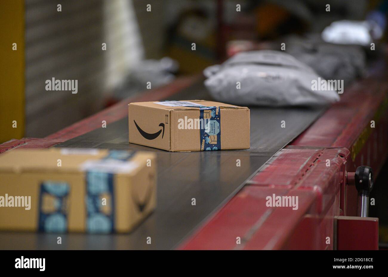 Ottendorf Okrilla, Deutschland. Dezember 2020. Amazon-Pakete befinden sich  auf einem Förderband im DHL Paketcenter. In der Zeit vor Weihnachten nimmt  das Paketvolumen deutlich zu. Quelle: Robert  Michael/dpa-Zentralbild/dpa/Alamy Live News ...