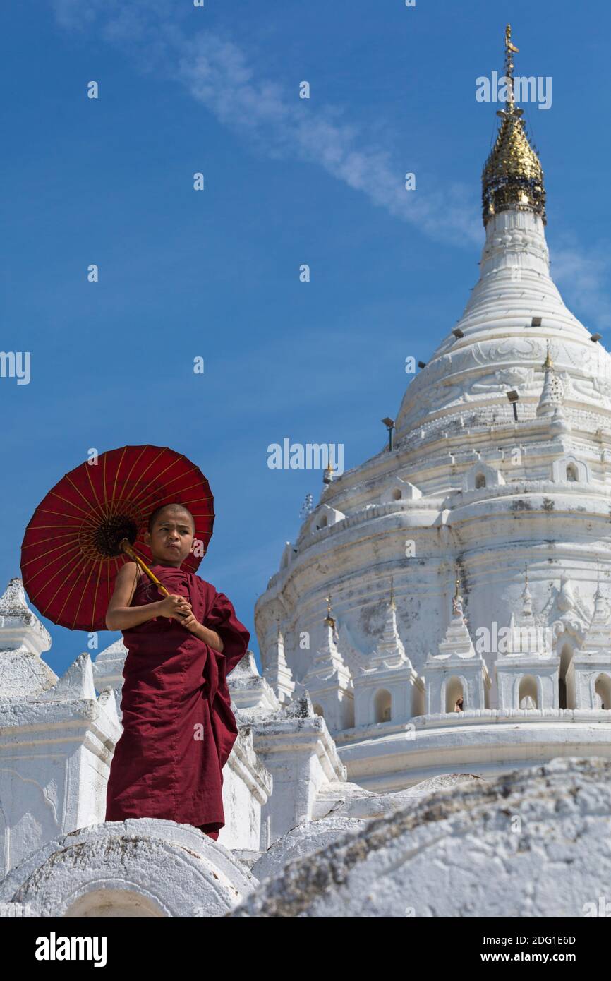 Junge Novizin buddhistischer Mönch holding Sonnenschirm am Myatheindan Pagode (auch als Hsinbyume Pagode bekannt), Mingun, Myanmar (Burma), Asien im Februar Stockfoto