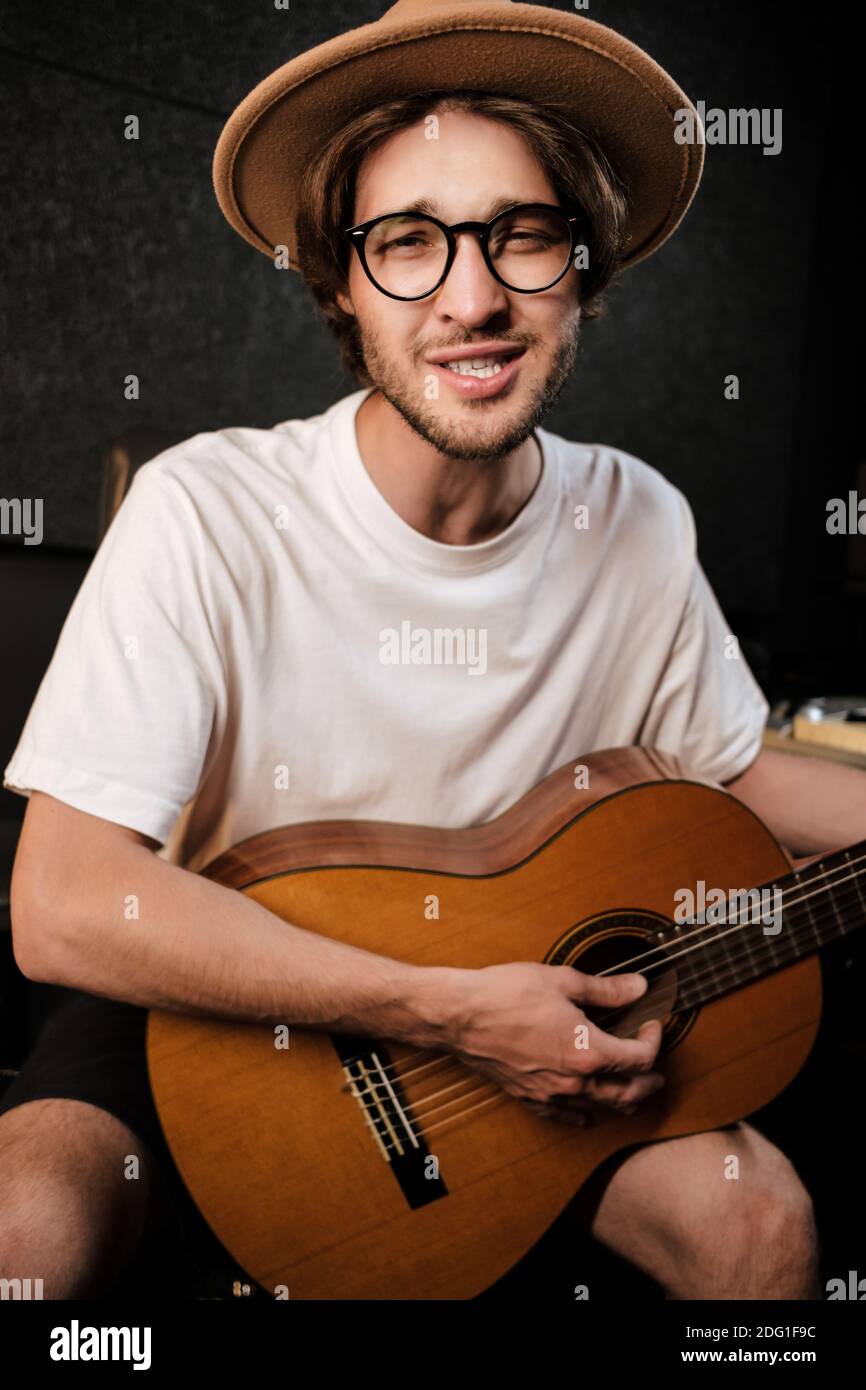 Portrait von attraktiven stilvollen Mann singen und spielen auf ein Gitarre im Aufnahmestudio Stockfoto