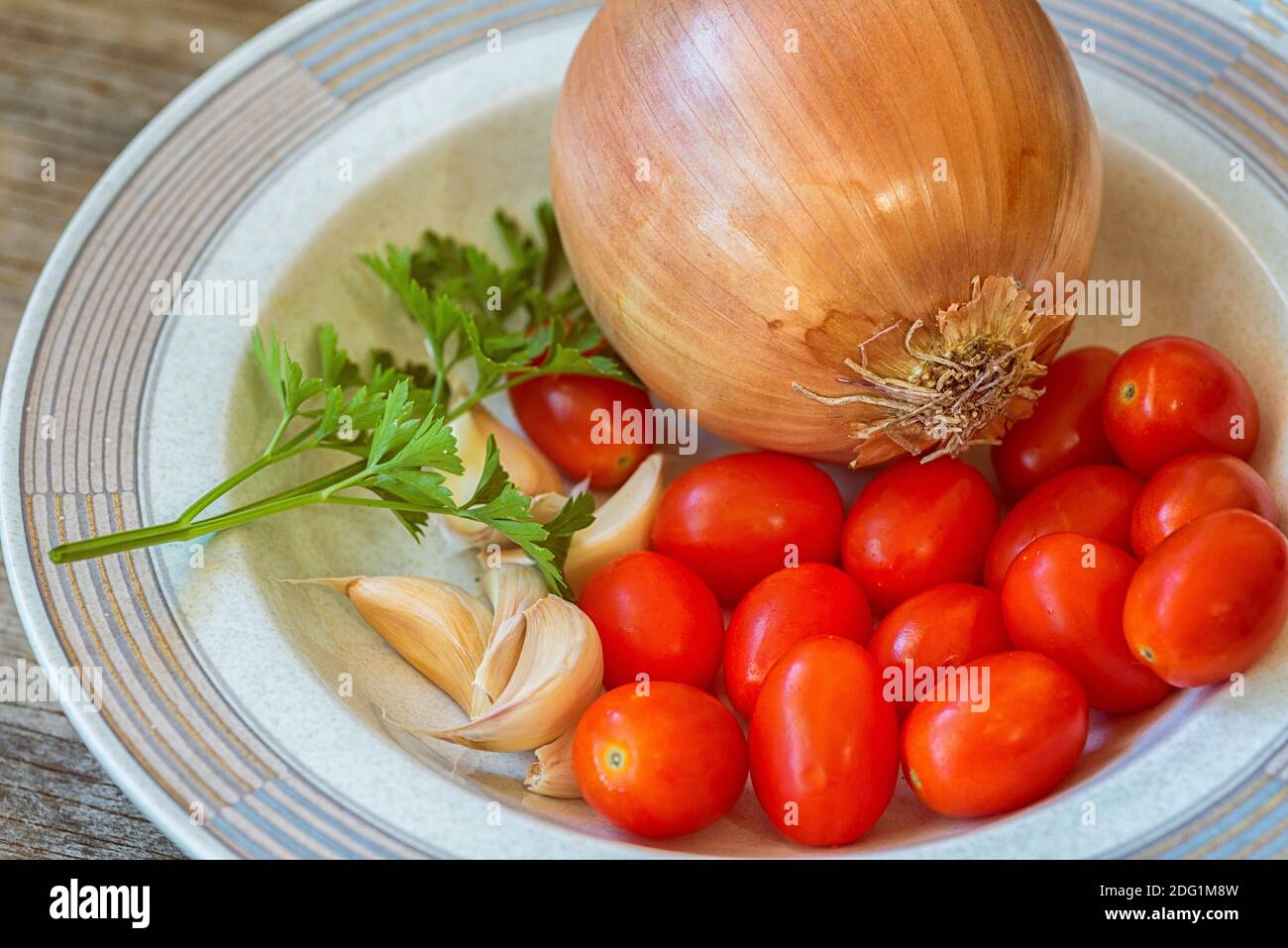Zwiebel, Knoblauch, Tomaten und Petersilie in einer Schüssel. Stockfoto