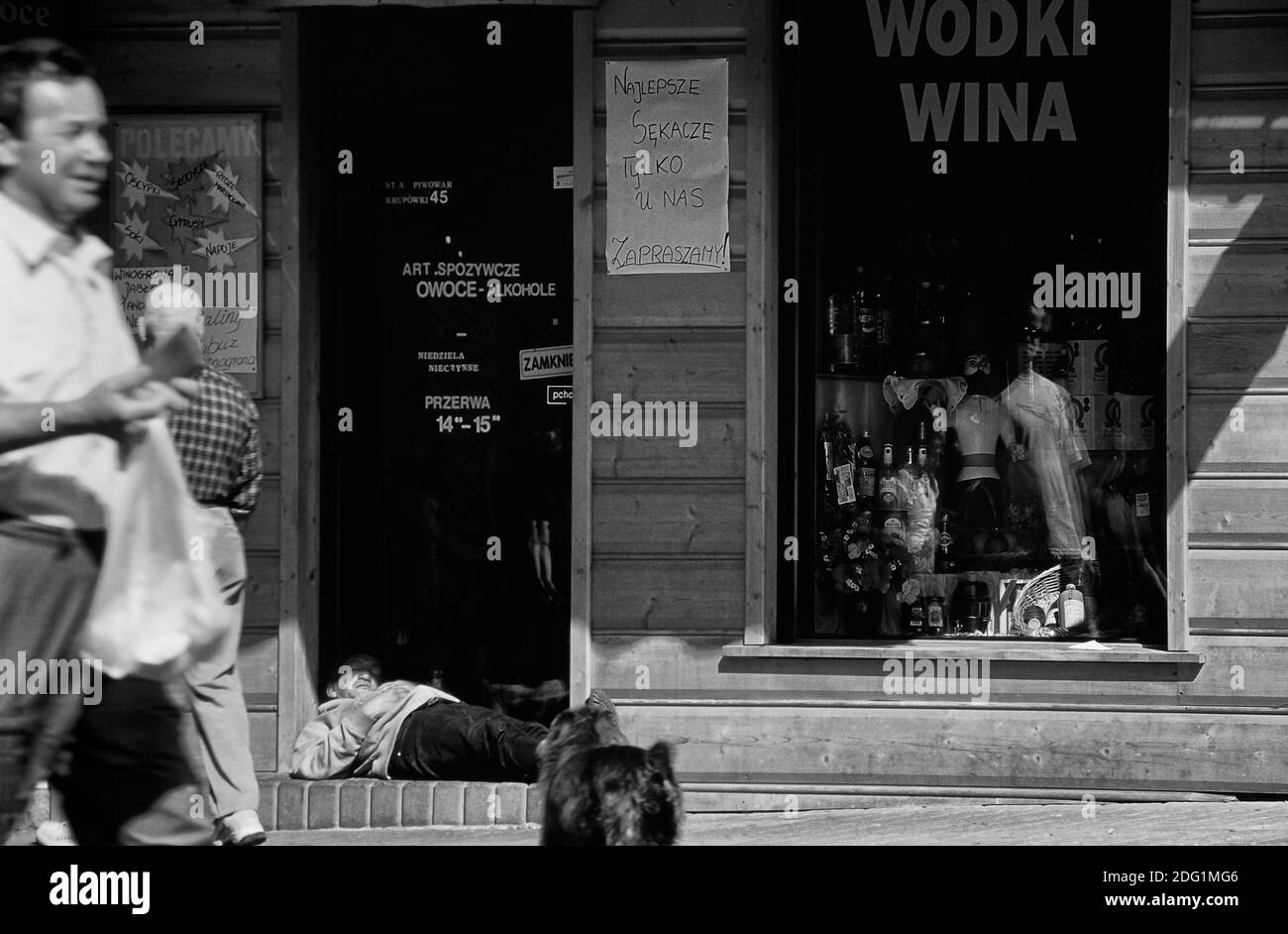 Ein betrunkener Mann, der in der Tür eines Wodka-Ladens schläft. Zakopane. Polen. Stockfoto