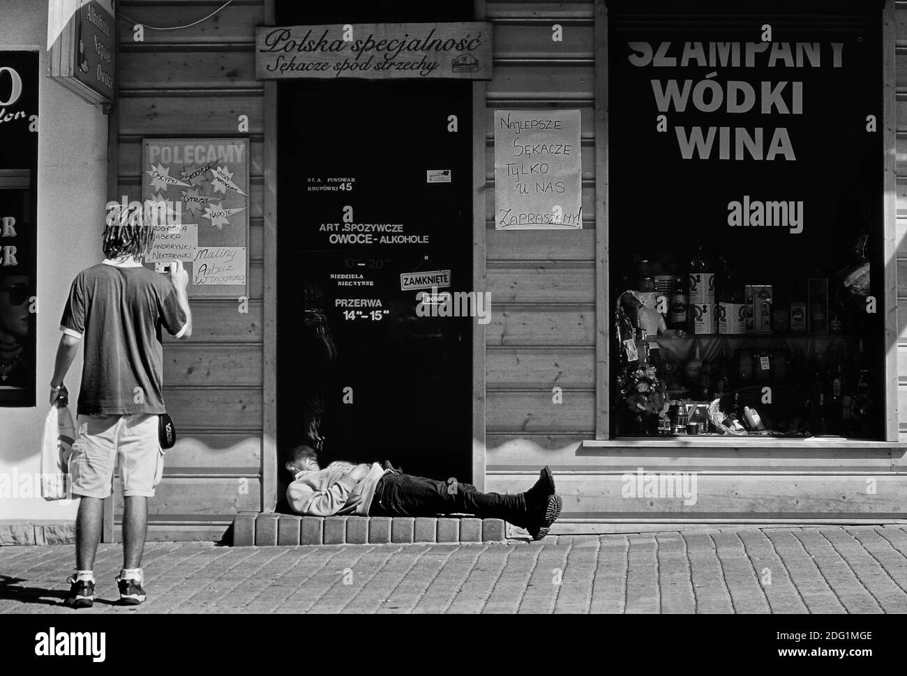 Ein betrunkener Mann, der in der Tür eines Wodka-Ladens schläft. Zakopane. Polen. Stockfoto