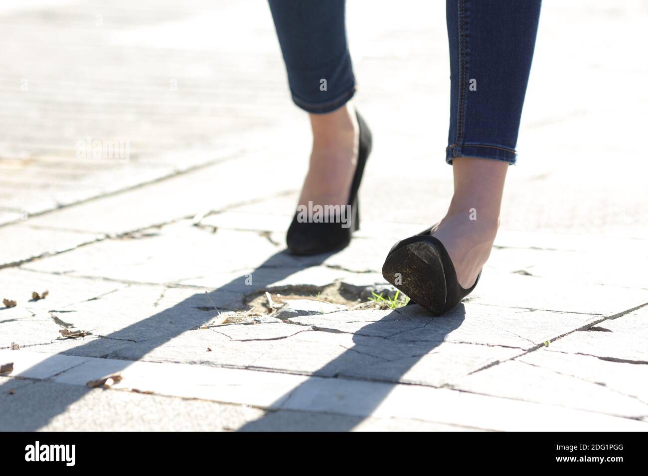 Nahaufnahme einer Frau Beine mit High Heels verstauchen Knöchel beim Gehen auf der Straße Stockfoto