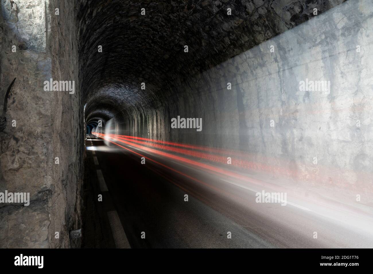 Lange Belichtung, Auto Licht Spur in einem dunklen Bergtunnel Stockfoto