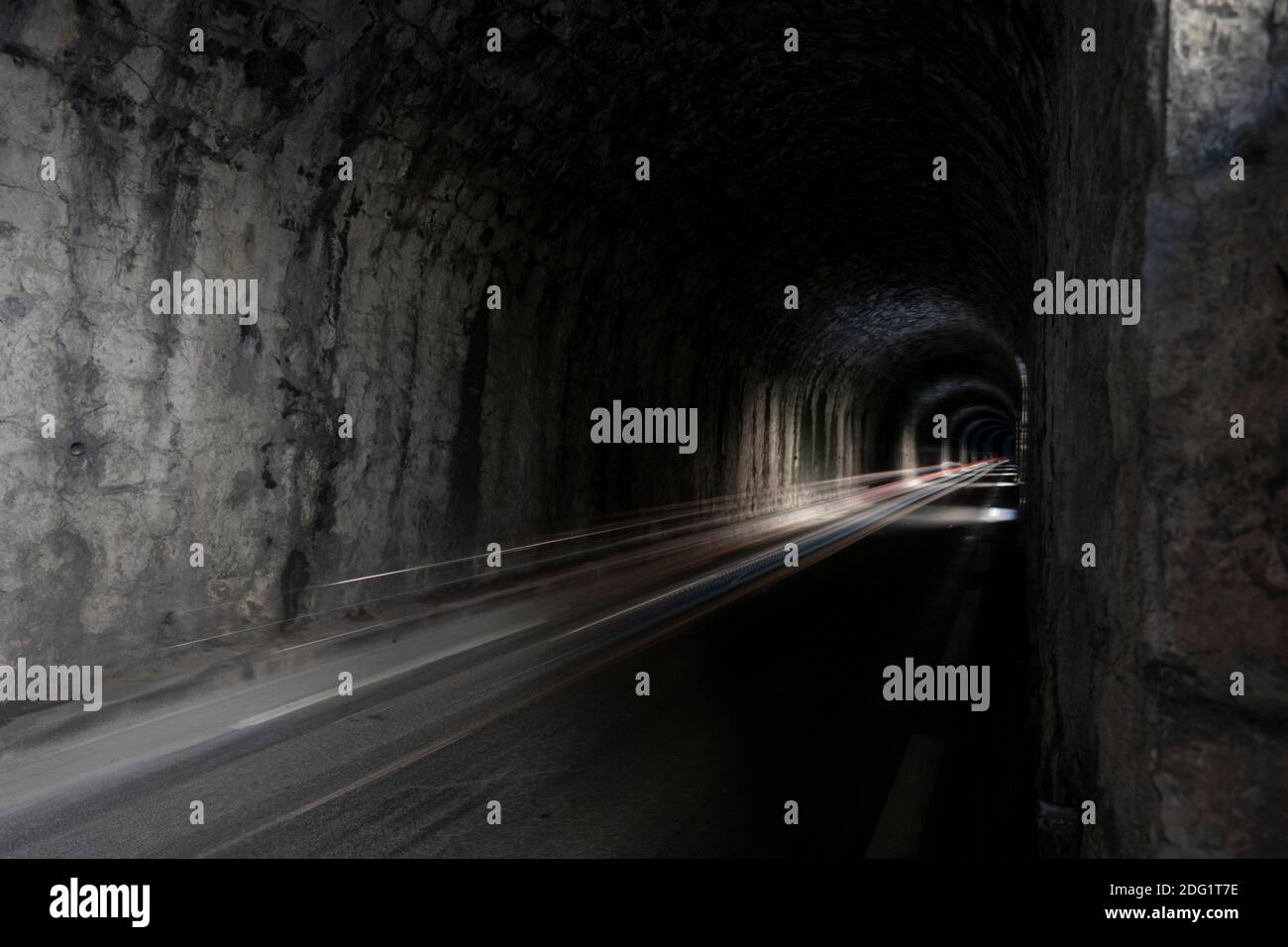 Lange Belichtung, Auto Licht Spur in einem dunklen Bergtunnel Stockfoto