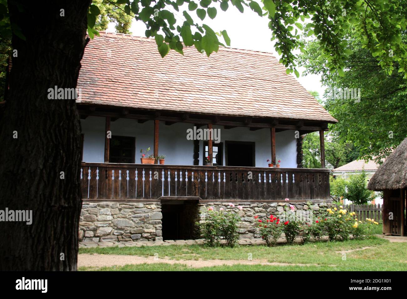 Das Dorfmuseum, Bukarest, Rumänien. Authentisches Haus aus dem 19. Jahrhundert aus Siebenbürgen, mit geschnitzter Holzveranda, Flussfelsen-Fundament und Keller. Stockfoto