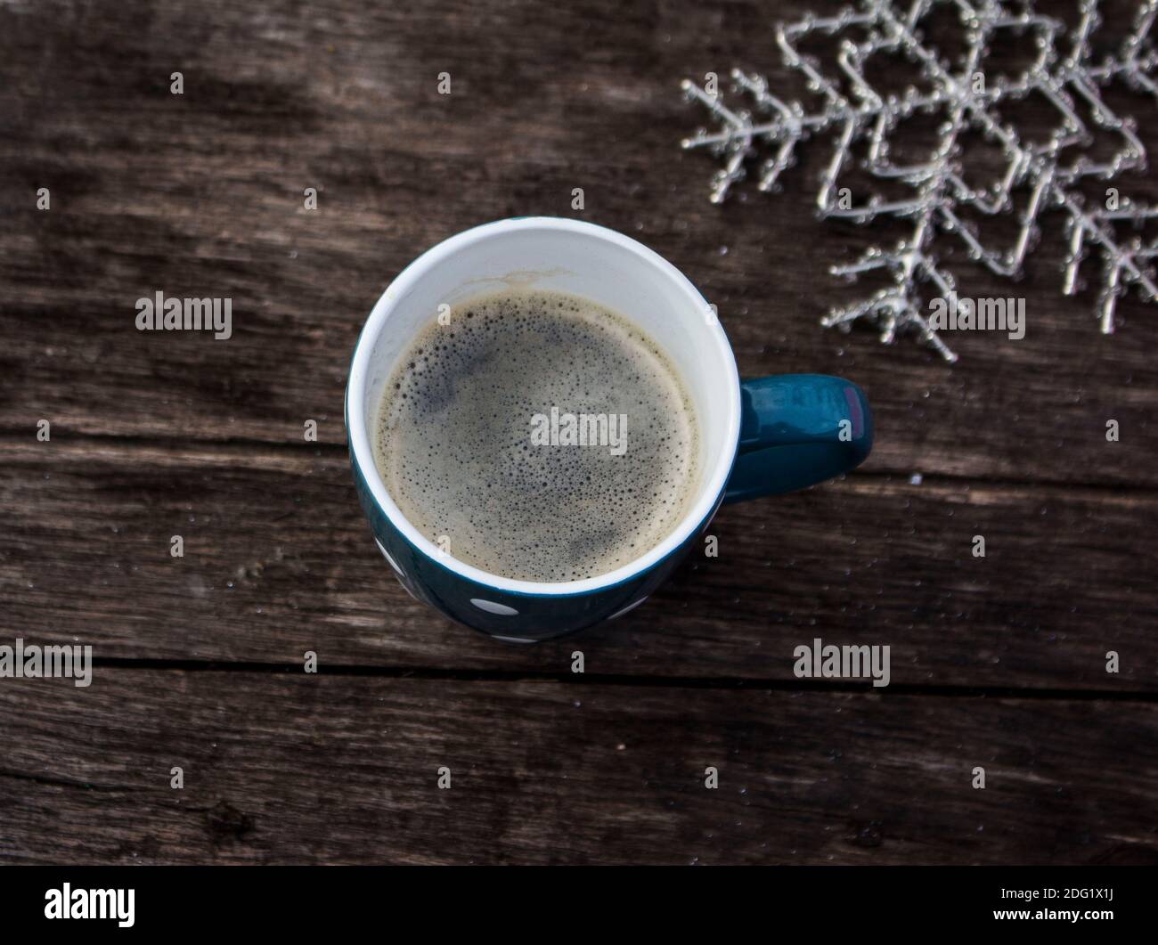 Einzelne blaue Tasse Kaffee mit Schneeflocken Ornament Stockfoto