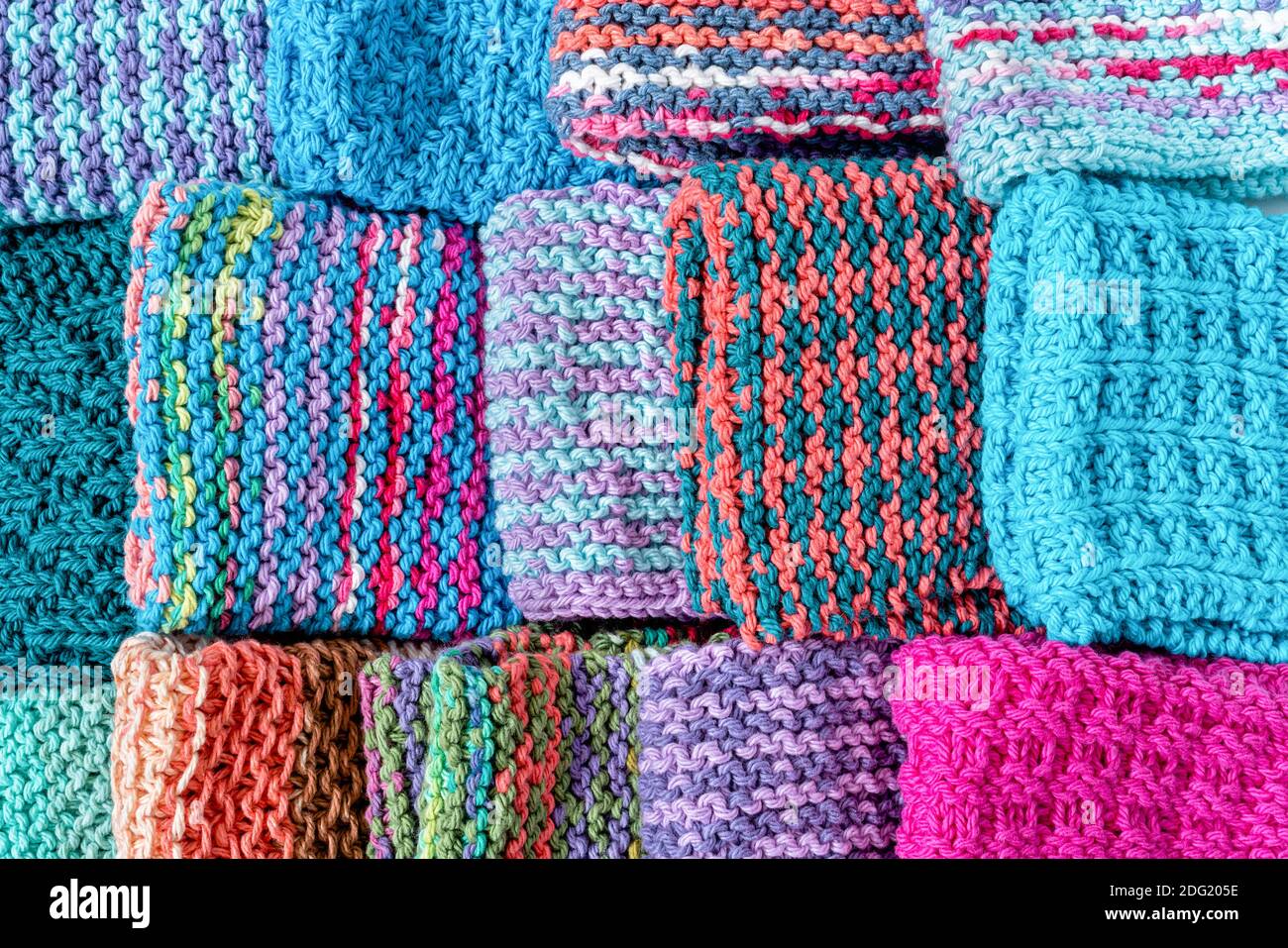 Eine bunte Auswahl an hausgemachten gestrickten Baumwollteller Kleidung. Stockfoto