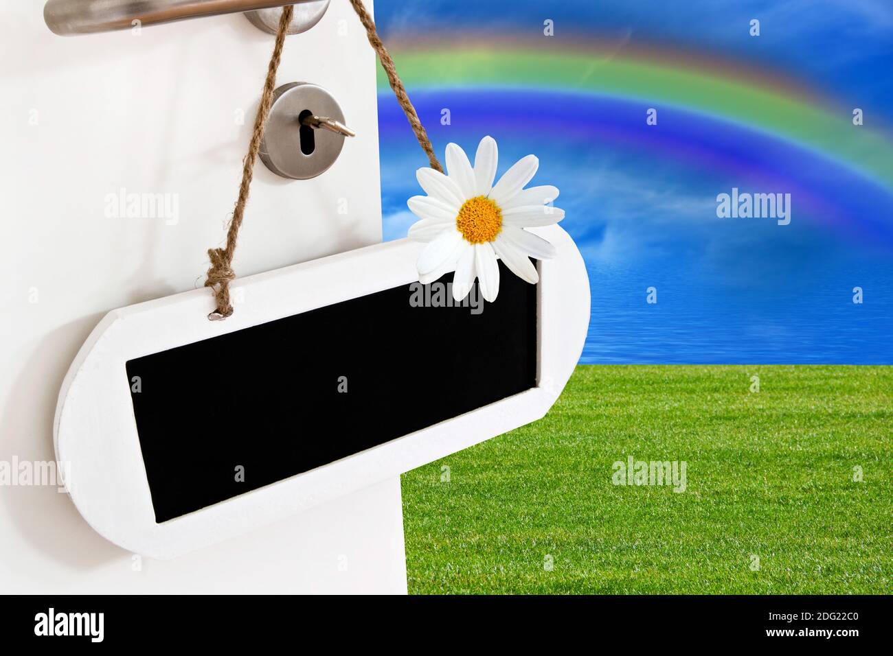 Offene Tür mit Kreidetafel , Himmel, Rasen und Regenbogen Stockfoto