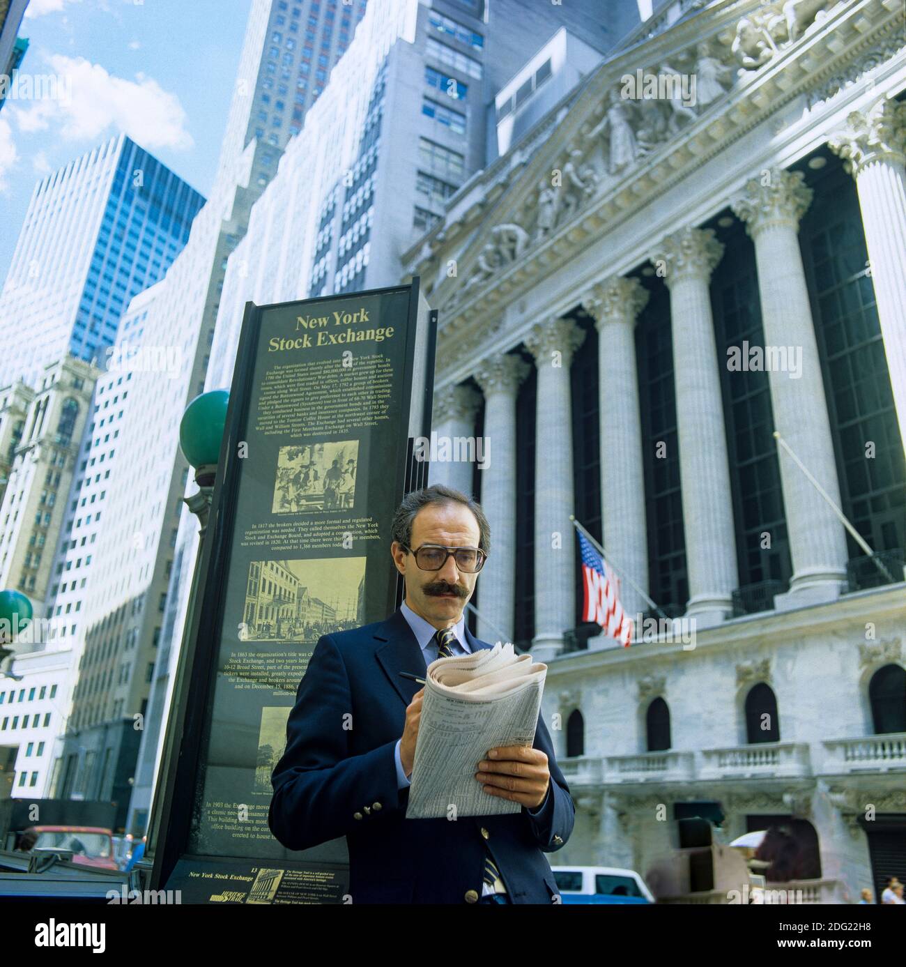 New York 1985, man überprüft die Aktienkurse im Wall Street Journal, NYSE Stock Exchange Building Fassade, Broad Street, Manhattan, New York City, NY, NYC, USA, Stockfoto