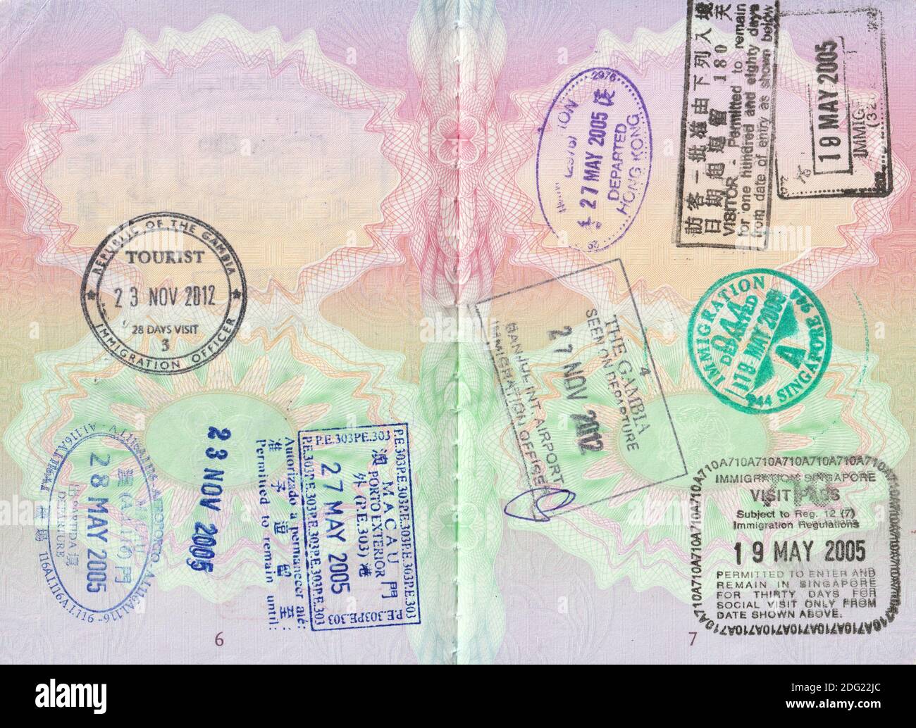 Britische Passseiten mit 2005 Hong Kong ein- und Ausfahrten; 2005 Singapur ein- und Ausfahrten; 2005 Macau ein- und Ausfahrten; und 2012 Gambia (Banjul) ein- und Ausreisestempel Stockfoto