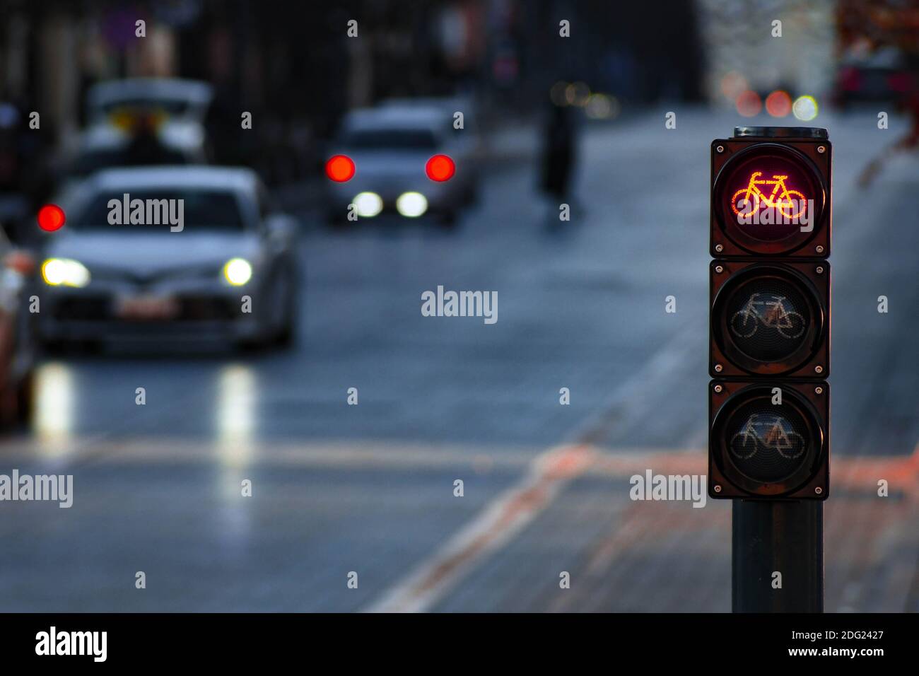 Nachhaltiger Verkehr. Fahrradverkehrssignal, rote Ampel, Stoppschild, Rennrad, kostenlose Fahrradzone oder -Bereich, Bike-Sharing, mit Verkehr im Hintergrund Stockfoto