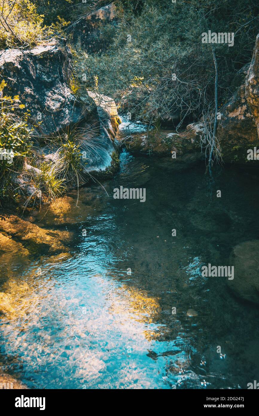 Kleiner kristallklarer Wasserfall im Wald auf einem Berg in Prades, Tarragona, Spanien. Stockfoto