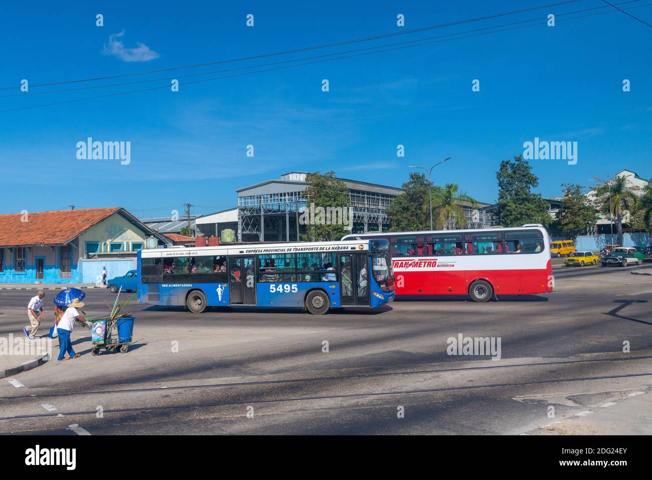 Öffentliche Verkehrsmittel Busse in der kubanischen Hauptstadt. Ein Straßenkehrer schiebt seinen Wagen in die Allee, die den Lebensstil auf der Insel zeigt. Stockfoto