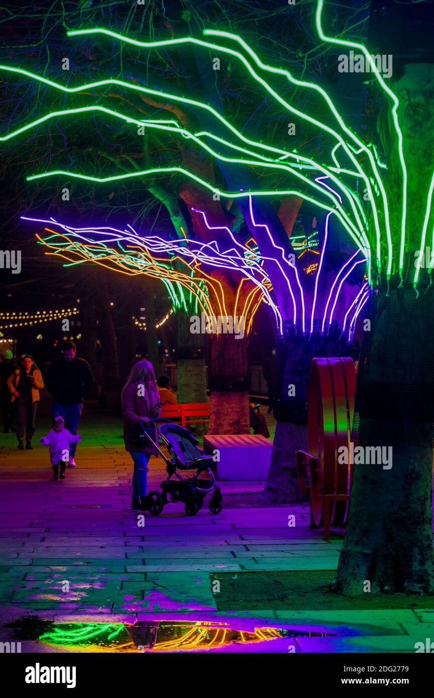 London, Großbritannien. Dezember 2020. David Ogle's Lumen - EINE Reihe von Platanen am Flussufer, die mit leuchtendem Neon beleuchtet sind und ein buntes Baldachin über den Köpfen von Fußgängern schaffen - Winter Light: Eine neue Open-Air-Ausstellung, die das Gelände des Southbank Centre mit leuchtenden Kunstwerken animiert. Es umfasst über 15 Kunstwerke und neue Aufträge, die mit Licht, Farbe und Animation zu machen. Sie bleiben bis Ende Februar zu sehen. Kredit: Guy Bell/Alamy Live Nachrichten Stockfoto