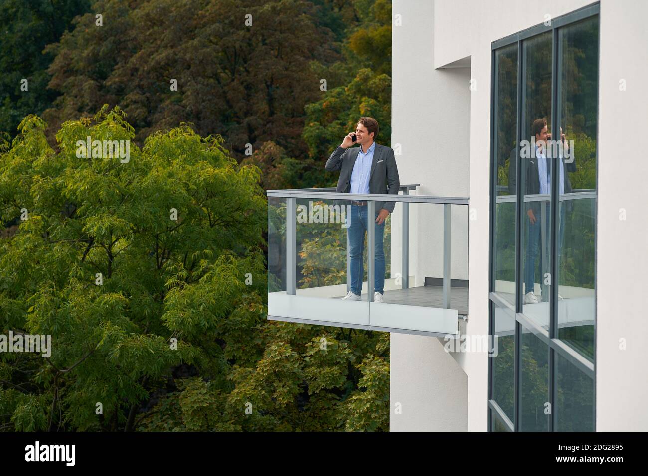 Geschäftsmann steht auf dem Balkon gegen die Natur Stockfoto