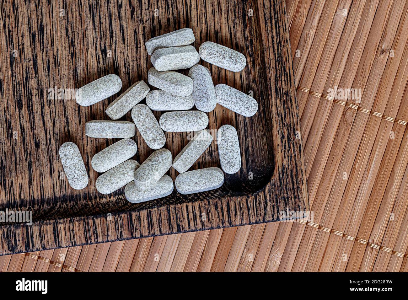 Nahaufnahme von Ester-c Tabletten auf einem hölzernen Hintergrund. Biologisch aktive Ergänzungen topview Foto. Stockfoto