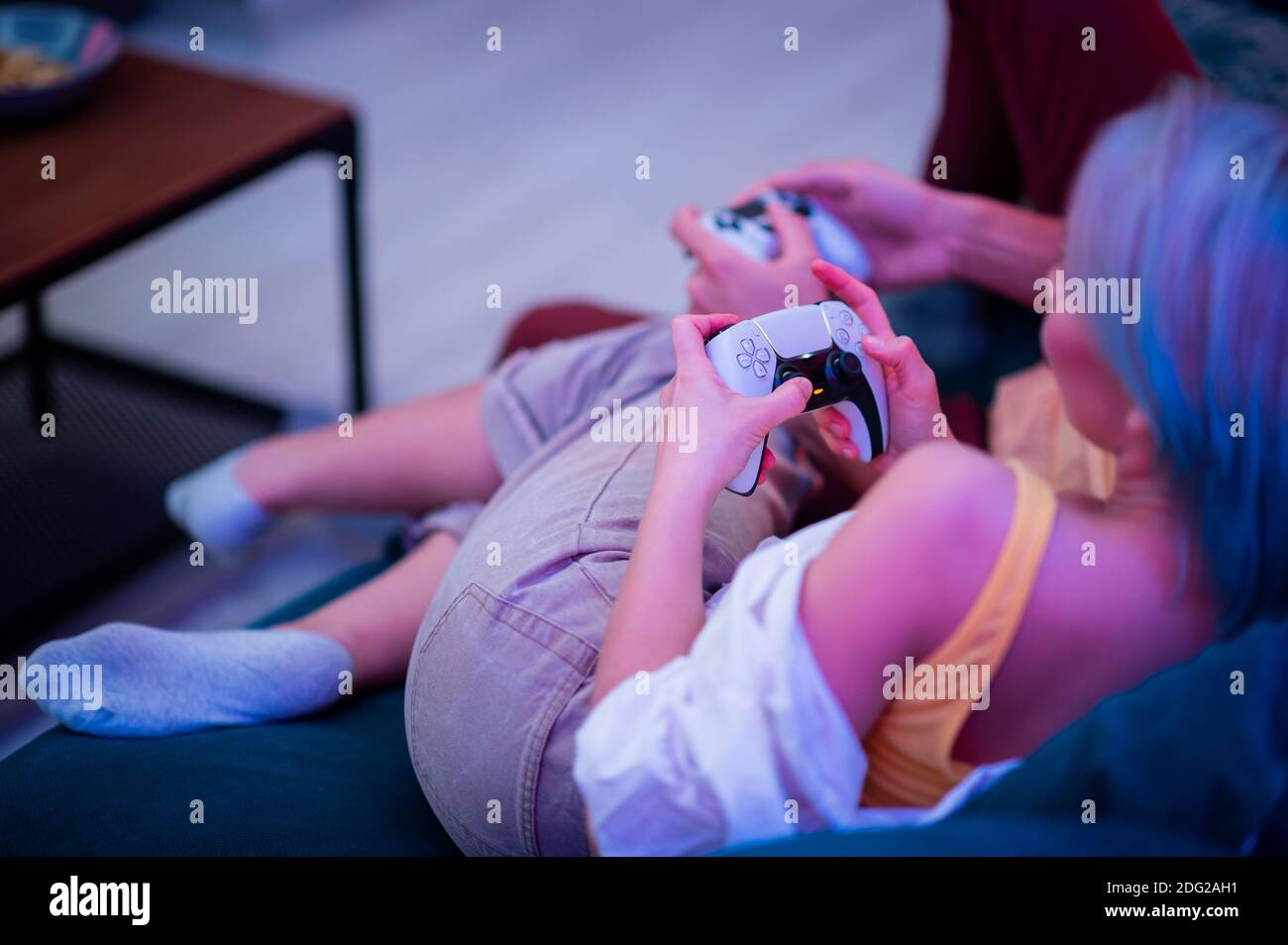 Verschiedene Generationen von PlayStation-Konsolen-Controllern: PS5 DualSense-Controller und PS4 DualShock-Controller in den Händen von Spielern. Moskau - Stockfoto