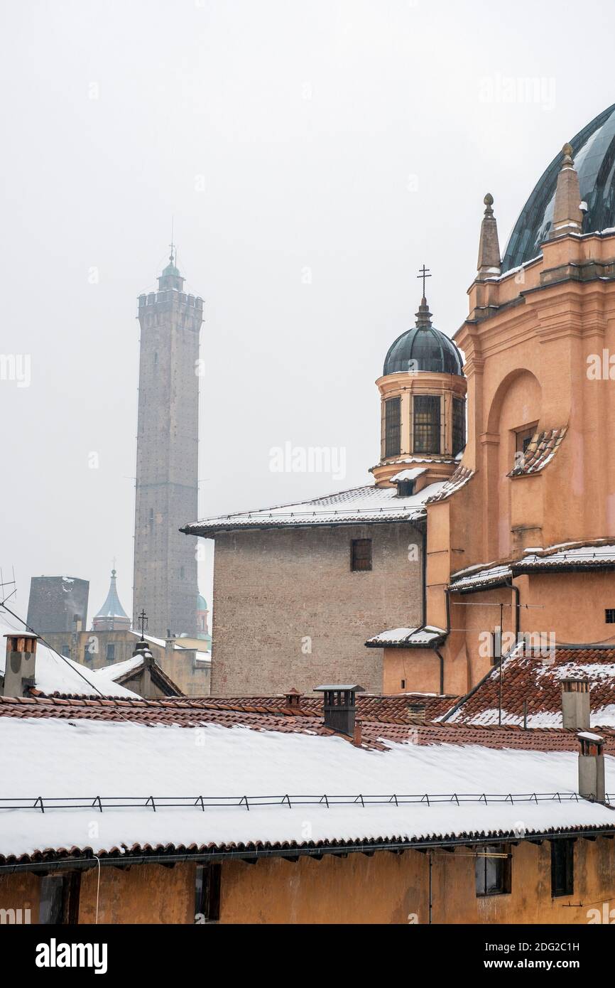 Blick über die schneebedeckten Dächer der Kirche Santa Maria della Vita, Bologna, Italien, und die schiefen Türme von Garisenda und degli Asinelli. Stockfoto