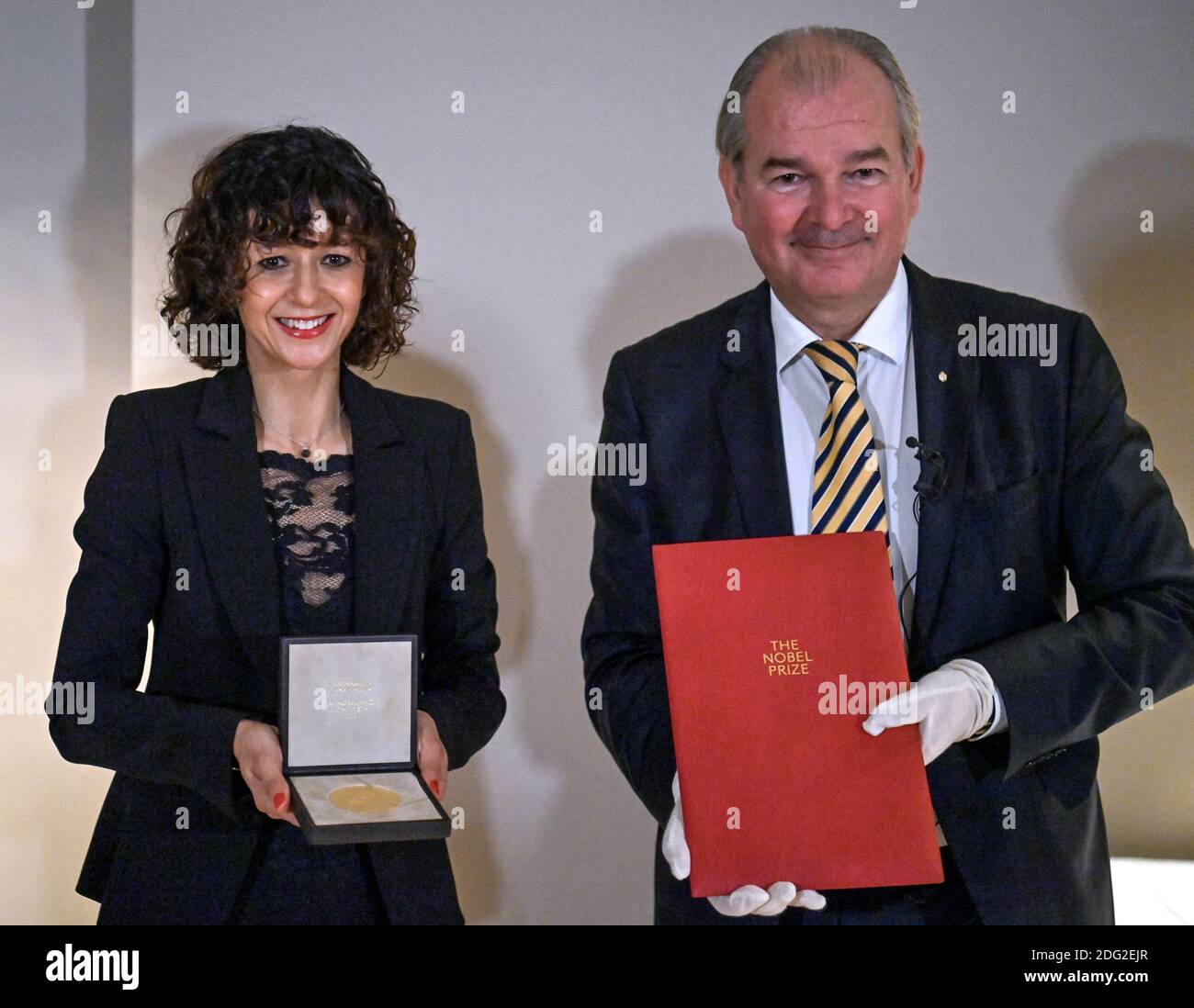 Berlin, Deutschland. Dezember 2020. Die Mikrobiologin Emmanuelle Charpentier zeigt die Medaille für ihren Nobelpreis für Chemie, den sie vom schwedischen Botschafter per Thöresson (r) erhalten hat. Am Montagabend erhielt sie die Urkunde auch in der Berliner Residenz des Botschafters. Denn die traditionelle Preisverleihung am 10. Dezember in Stockholm wird in diesem Jahr aufgrund der Corona-Pandemie nur online stattfinden. Quelle: John MacDougall/AFP/POOL/dpa/Alamy Live News Stockfoto