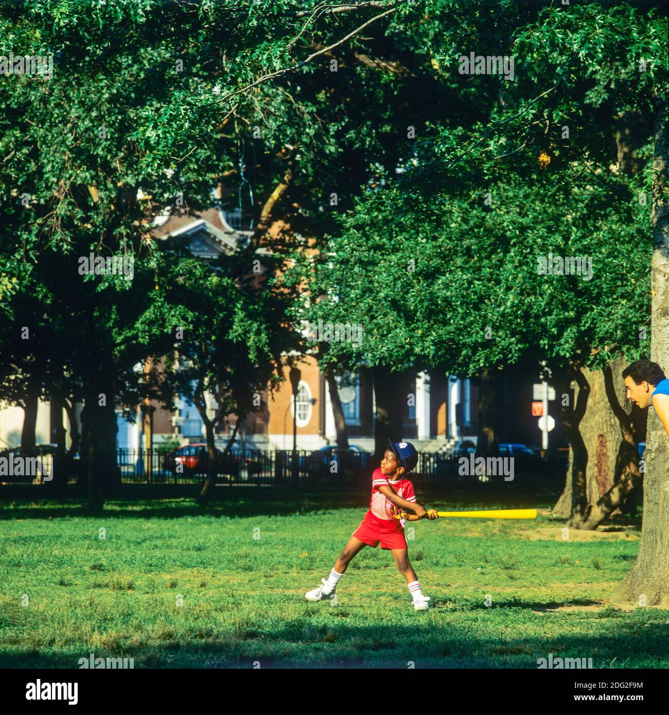 New York 1985, kleiner afroamerikanischer Junge, der Baseball spielt, schwingender Baseballschläger, Battery Park, Lower Manhattan, New York City, NY, NYC, USA, Stockfoto