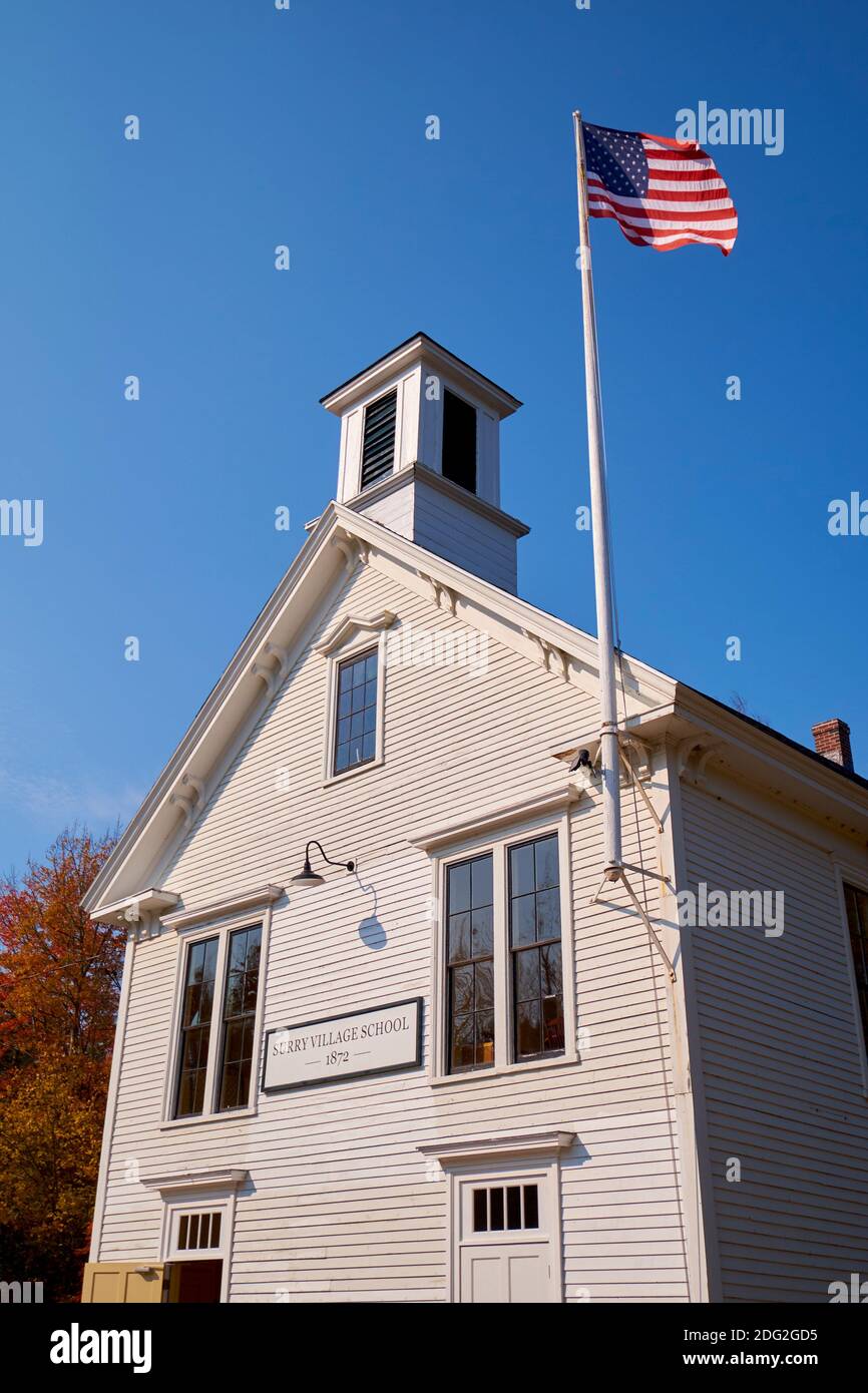 Außenansicht der alten, weißen, Klapptafel, Abstellgleis Surry Village Schule mit Fahnenmast. In Surry, Maine. Stockfoto