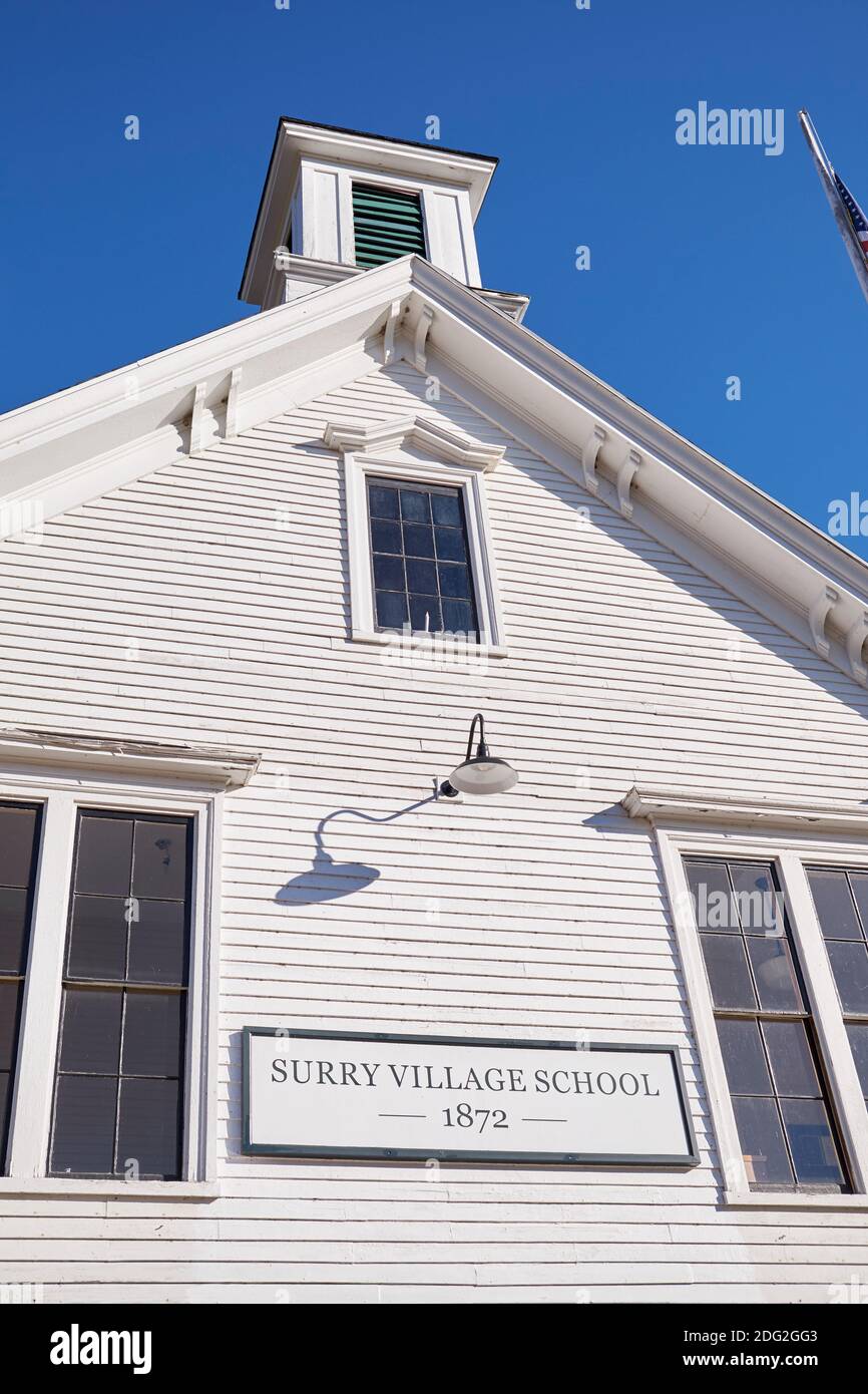 Außenansicht der alten, weißen, Klapptafel, Abstellgleis Surry Village Schule mit Fahnenmast. In Surry, Maine. Stockfoto