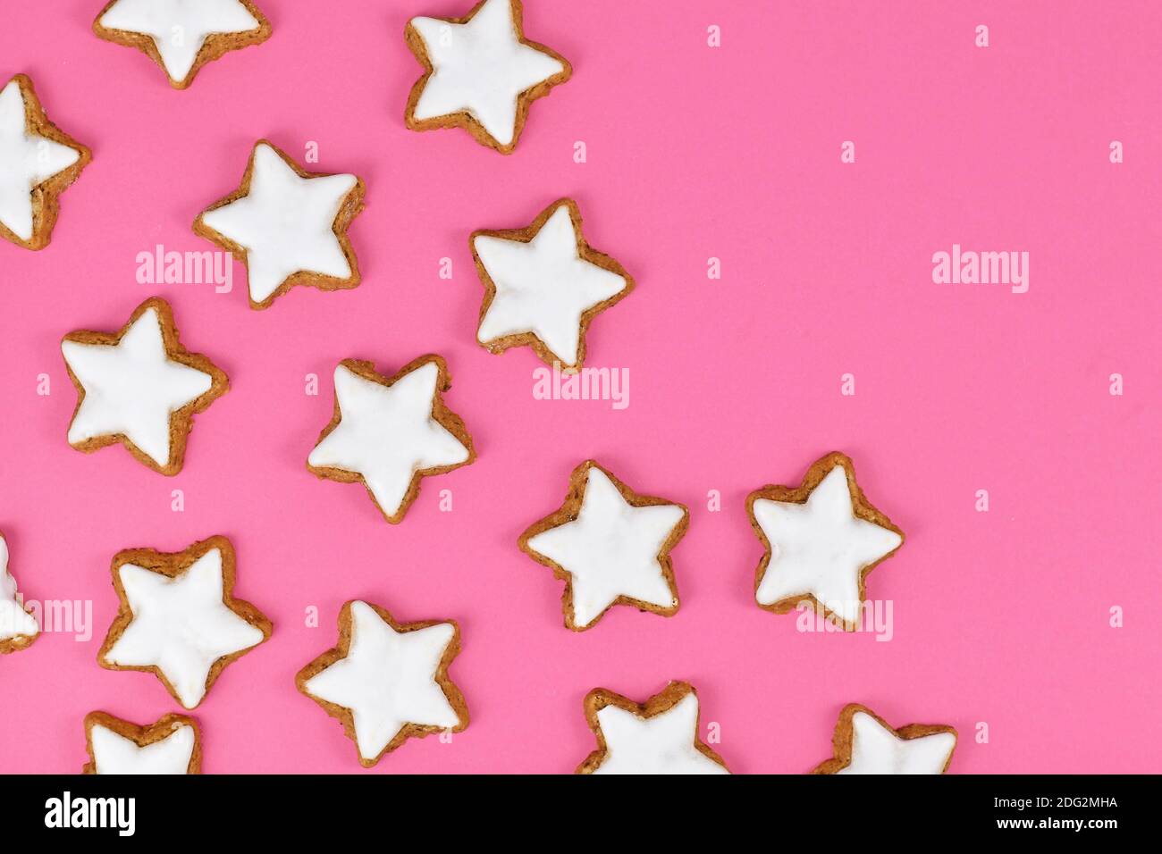 Deutsche sternförmige glasierte Zimt Weihnachtsplätzchen genannt 'Zimtsterne' auf Rosa Hintergrund Stockfoto