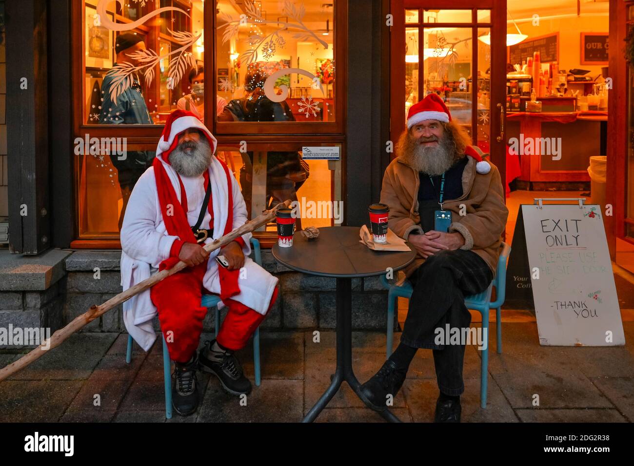 Wären Santas, Adel Berenjian und ein Freund im Delaneys Coffee Shop Patio, Dundarave, West Vancouver, British Columbia, Kanada Stockfoto