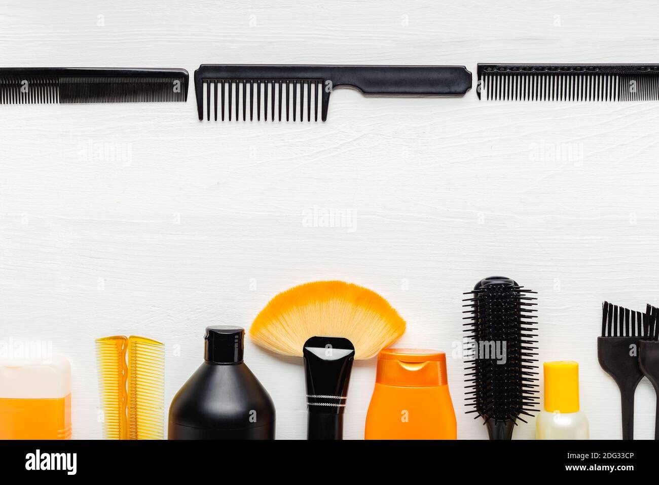Haarbürste, Kamm, Schere, Shampoo. Set Orange Schwarz. Friseurwerkzeuge, Friseursalon Ausrüstung für professionelle Friseursalon im Schönheitssalon, Haarschnitt Stockfoto