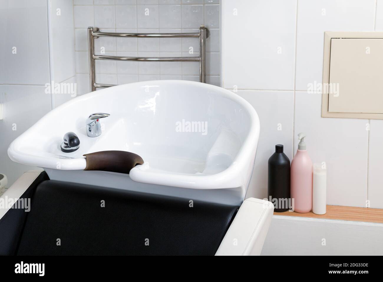 Haarwaschbecken zum Waschen der Haare im Schönheitssalon oder Friseur-Shop, Shampoos Haarkosmetik für Spa-Behandlung. Friseur Stylist Arbeitsplatz Stockfoto