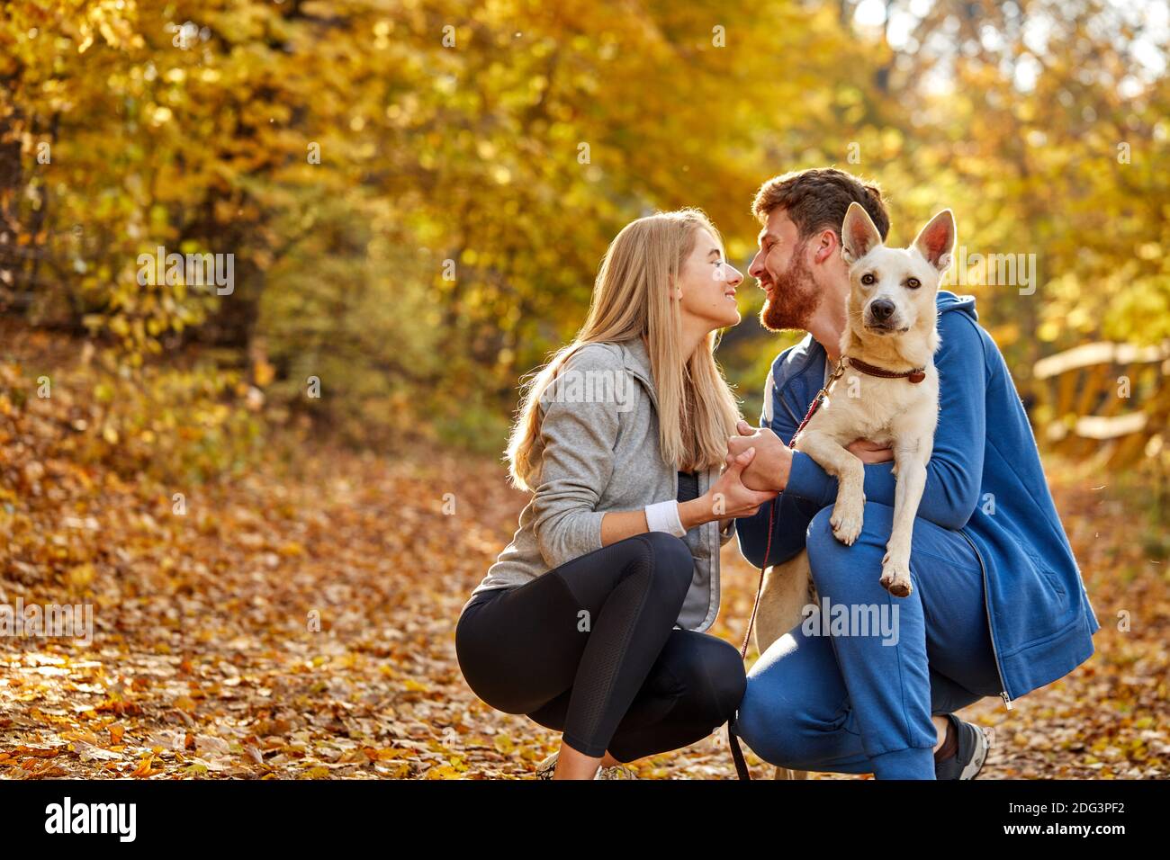 Paar gekleidet lässig Umarmung und einen Spaziergang in der Natur mit ihrem schönen schönen Hund, Herbstsaison Stockfoto