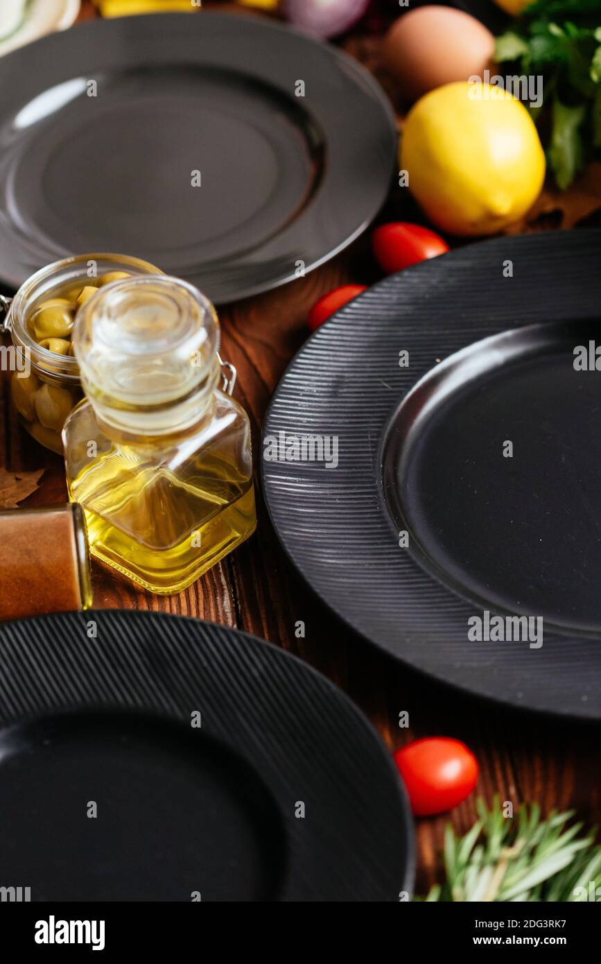Schwarze Teller auf einem hölzernen Hintergrund mit Gemüse und Obst Ausgelegt Stockfoto