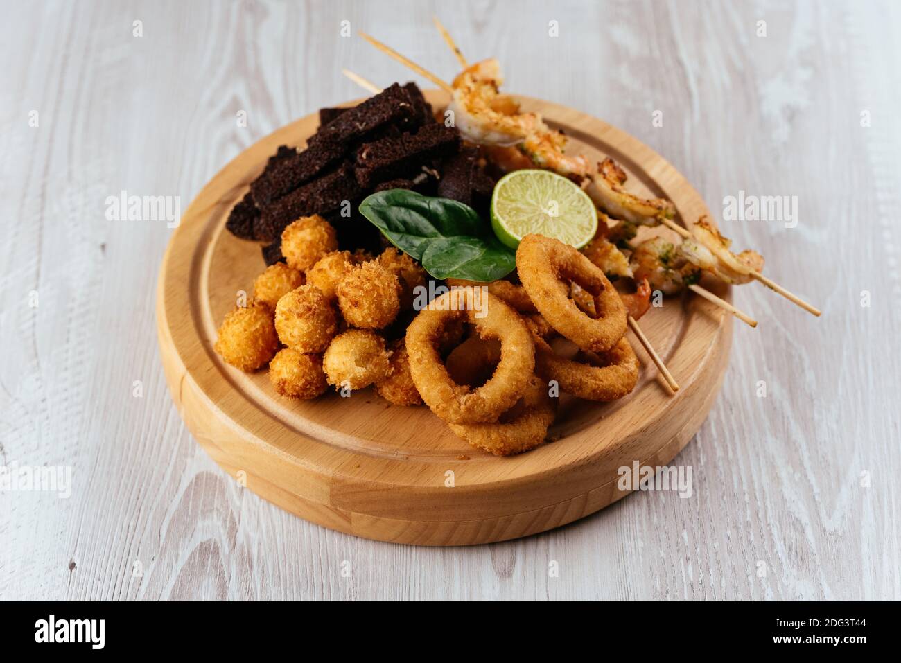 Biersnacks auf einem Holzbrett und hellem Hintergrund Stockfoto