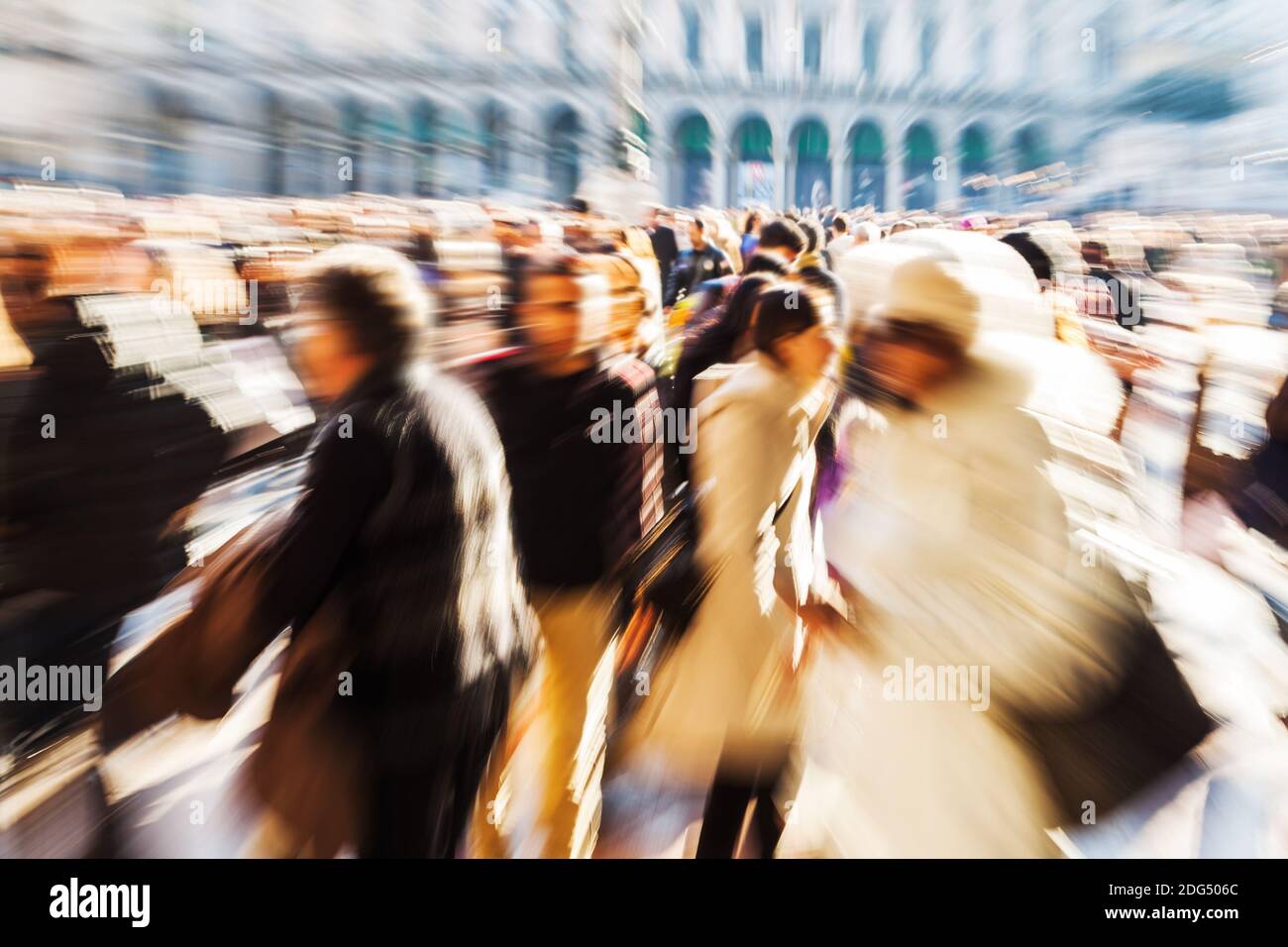 Menschenmassen, die auf einem Stadtplatz in Bewegung gehen Weichzeichnen und Zoomeffekt Stockfoto