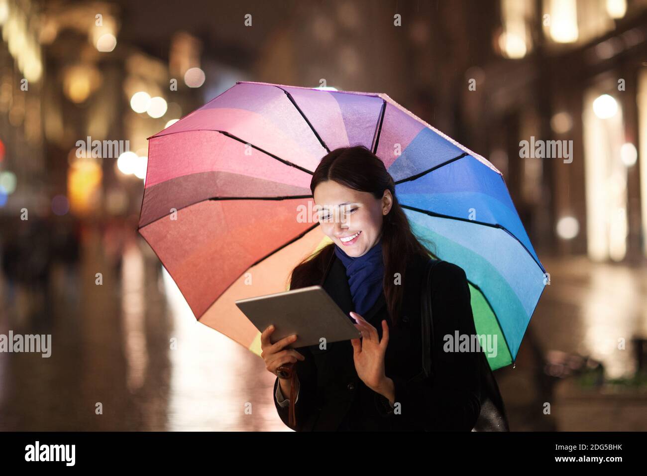 Frau mit Pad unter Dach in der Stadt am Abend Stockfoto