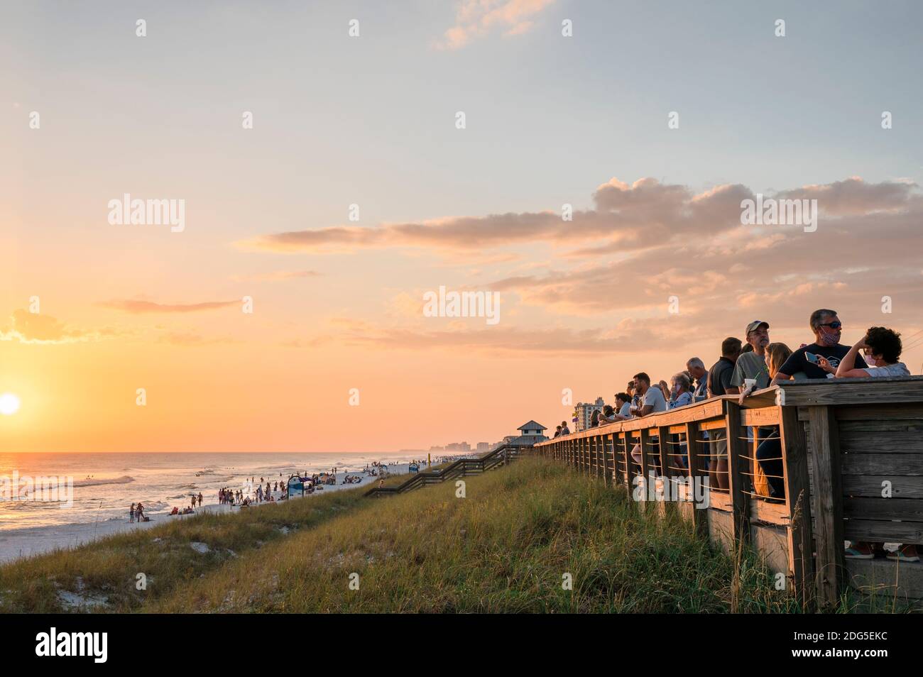 Touristen und Besucher beobachten einen Sonnenuntergang an der Florida Golfküste am Strand in South Walton County, Florida, USA. Stockfoto