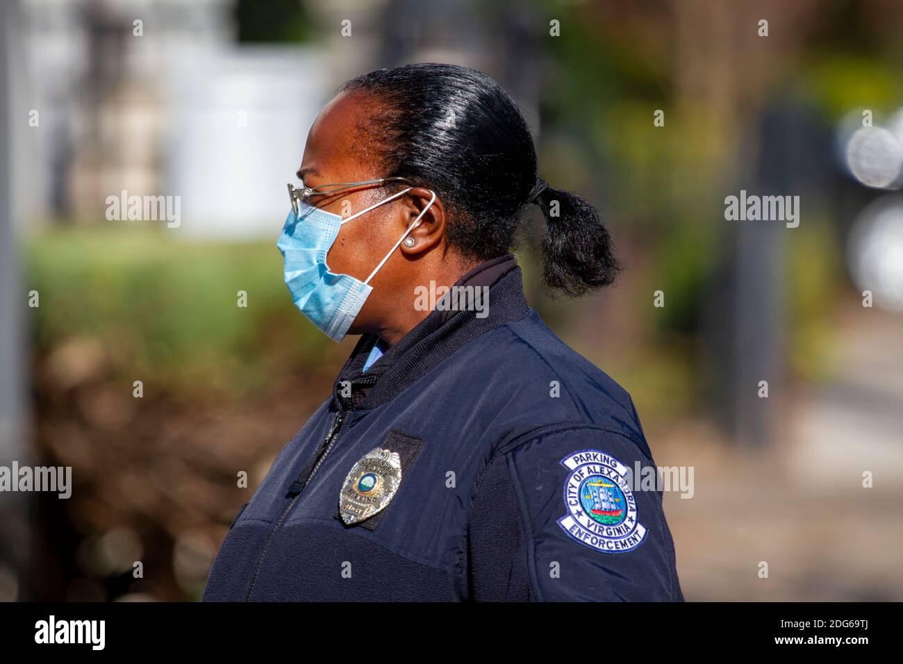 Alexandria, VA, USA 11-28-2020: Ein afroamerikanischer Polizeibeamter, der in der Abteilung für Parkplatzdurchsetzung arbeitet, ist im Freien im Dienst. Sie trägt Gesichtsmaske Stockfoto
