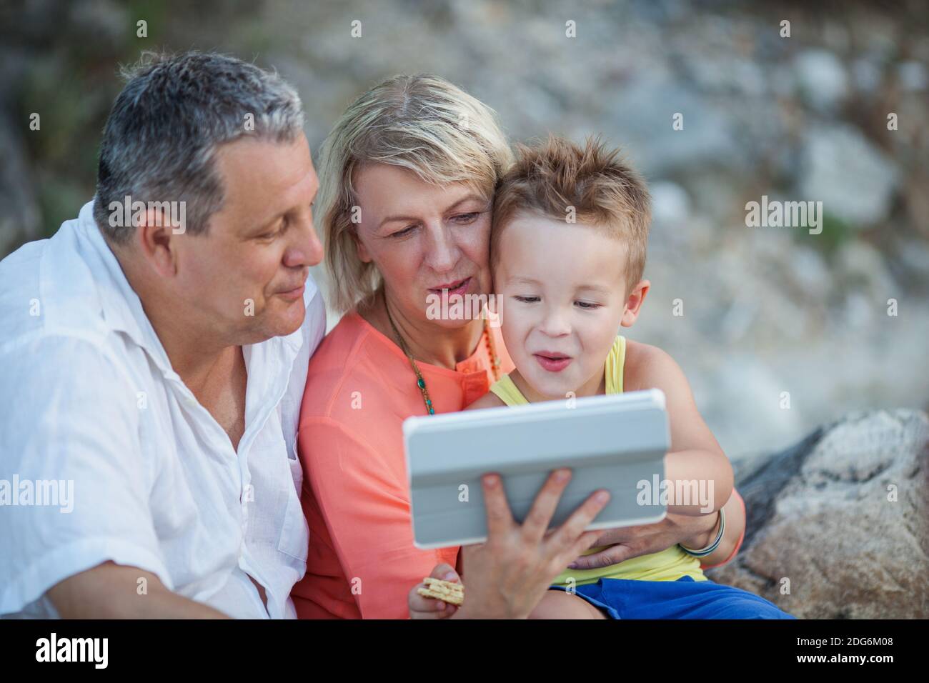Großeltern und Enkel mit Tablet-PC im Freien Stockfoto