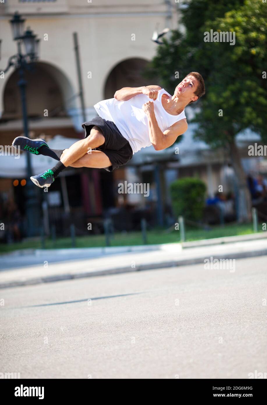Junger Mann, der auf der Straße einen Salto spielt Stockfoto