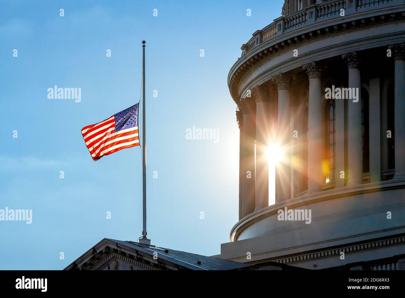 Washington, DC, USA, 7. Dezember 2020. Im Bild: Die amerikanische Flagge, die von der Sonne beleuchtet wird, während sie auf dem halben Stab des US-Kapitols fliegt, in Erinnerung an die Toten, die während des Angriffs auf Pearl Harbor an diesem Datum im Jahr 1941 verloren wurden, was dazu führte, dass die Vereinigten Staaten den Alliierten im Zweiten Weltkrieg anschlossen Jedes Jahr am 7. Dezember fliegen Flaggen bei Halb-Mitarbeitern zur Beobachtung des National Pearl Harbor Remembrance Day. Kredit: Allison C Bailey/Alamy Live Nachrichten Stockfoto