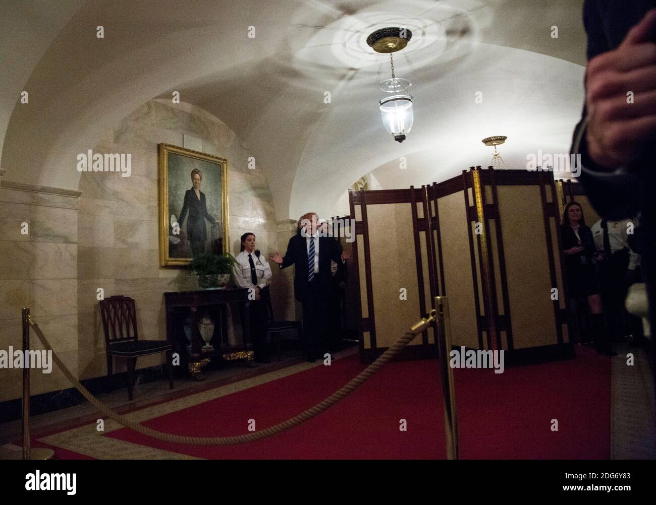US-Präsident Donald Trump geht in einem Korridor des Weißen Hauses, um Besucher zu begrüßen, während ein Porträt von Hillary Clinton am 7. März 2017 in Washington, DC, USA, an der Wand hängt. Foto von Aude Guerrucci/Pool/ABACAPRESS.COM Stockfoto