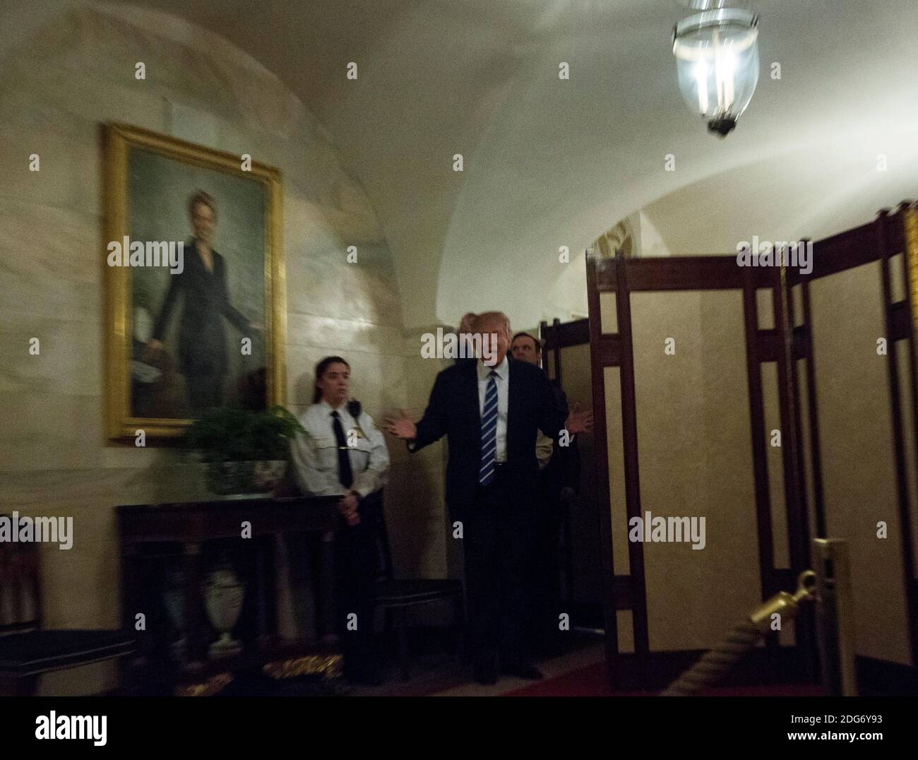 US-Präsident Donald Trump geht in einem Korridor des Weißen Hauses, um Besucher zu begrüßen, während ein Porträt von Hillary Clinton am 7. März 2017 in Washington, DC, USA, an der Wand hängt. Foto von Aude Guerrucci/Pool/ABACAPRESS.COM Stockfoto