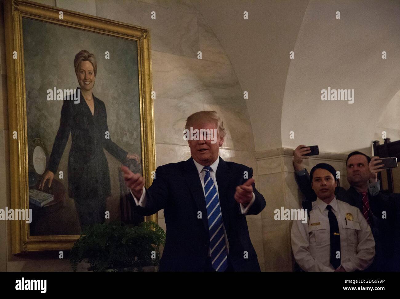US-Präsident Donald Trump geht in einem Korridor des Weißen Hauses, um Besucher zu begrüßen, während ein Porträt von Hillary Clinton am 7. März 2017 in Washington, DC, USA, an der Wand hängt. Foto von Aude Guerrucci/Pool/ABACAPRESS.COM Stockfoto