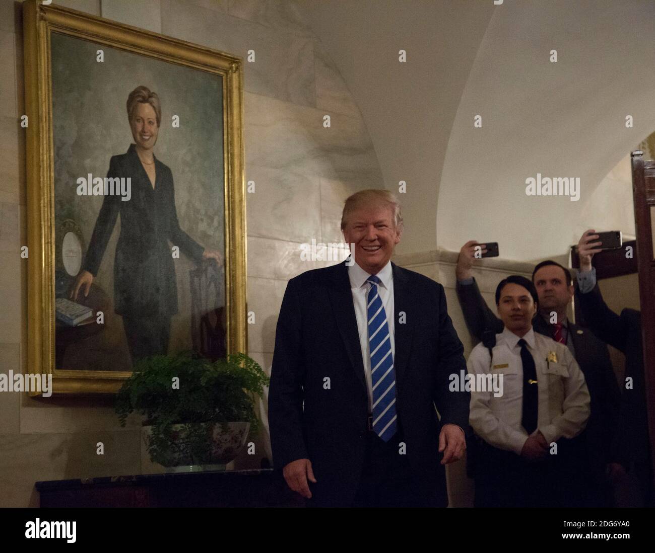 US-Präsident Donald Trump geht in einem Korridor des Weißen Hauses, um Besucher zu begrüßen, während ein Porträt von Hillary Clinton am 7. März 2017 in Washington, DC, USA, an der Wand hängt. Foto von Aude Guerrucci/Pool/ABACAPRESS.COM Stockfoto